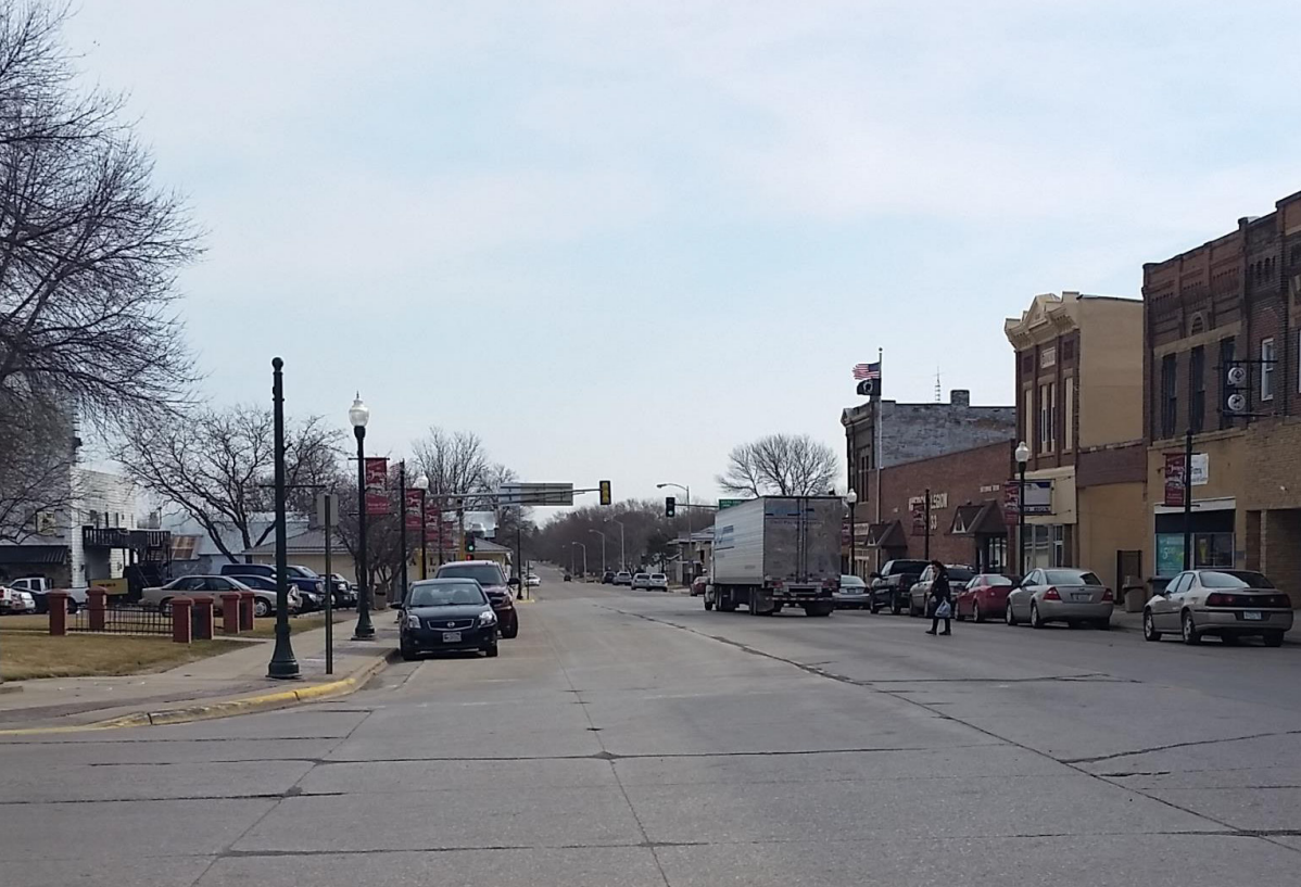 Highway 4 in St. James before construction, showing an intersection with wide travel lanes, parking lanes on either side, narrow sidewalks, and no crosswalks