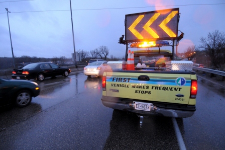 FIRST truck using arrows to direct cars around a crash to keep traffic moving.